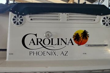 Carolina boat name design on a boat transom at sunset with palm trees.